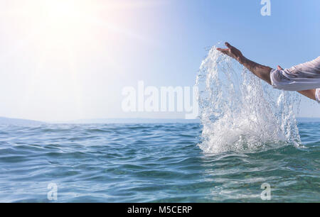 Le mani delle donne fare lo spruzzo di mare. Foto Stock