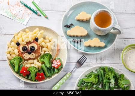 Funny Lion cibo faccia con cotoletta, pasta e verdure Foto Stock