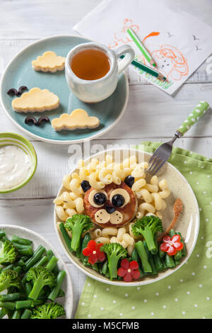 Funny Lion cibo faccia con cotoletta, pasta e verdure Foto Stock