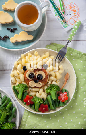 Funny Lion cibo faccia con cotoletta, pasta e verdure Foto Stock