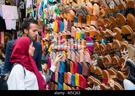 Coppia musulmana shopping cuoio marocchino pantofole in open market store Foto Stock