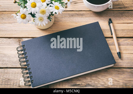 Chiuso il notebook in bianco e lo sfondo in legno, vista da sopra, lo spazio per il testo Foto Stock