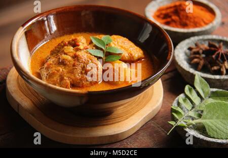 Pollo e curry di patate. Indiano-influenzato piatto di pollo e le patate in spesse zuppa di curry; un lato piatto per Il Roti Prata. Foto Stock