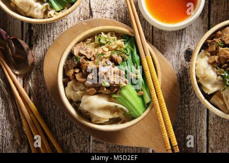 Noodle al pollo e wonton Soup. Popolare il cibo cinese piatto di noodle all'uovo con pollo e funghi, fagottini, cavolo cinese e il brodo di pollo. Foto Stock