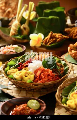 Il Nasi Campur Bali. Popolare Balinese tradizionale piatto di riso al vapore serviti con vari contorni. Foto Stock