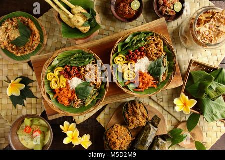 Il Nasi Campur Bali. Popolare Balinese tradizionale piatto di riso al vapore serviti con vari contorni. Foto Stock