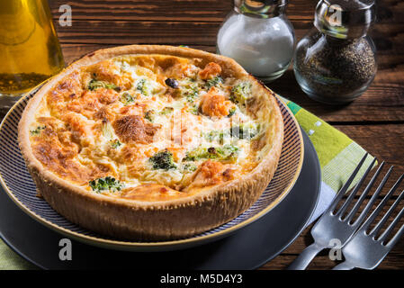 Classic salmone e broccoli quiche fatta da pasta frolla con cime di broccoli e salmone affumicato in un cremoso intervallo libero crema di uovo Foto Stock