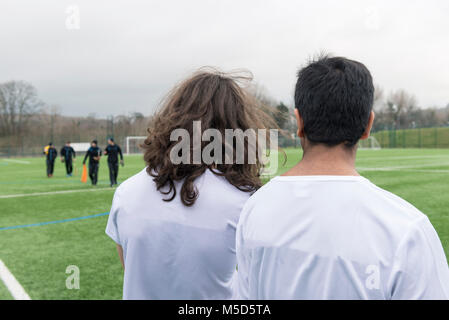 Due giovani tifosi guardare il sussex cricket a piedi passato sulla loro attesa per la pratica professionale campo sportivo Foto Stock