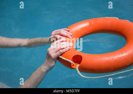 Close up donna mani lifebelt in mare. Annegamento di emergenza consentono di concetto Foto Stock