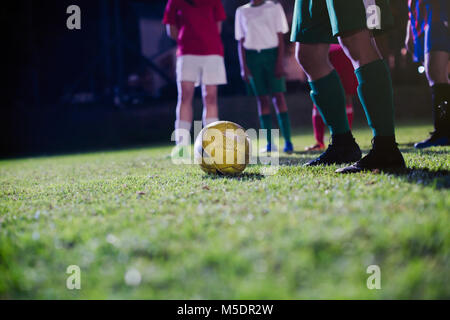 Giovani femmine i giocatori di calcio la pratica sul campo di notte Foto Stock