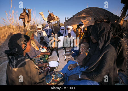 Niger, Talak nei pressi di Agadez. Deserto del Sahara. Montagne d'aria. Il Sahel. Persone di etnia Tuareg. Camp. Famiglia seduti insieme. In Medio: capra. Cammelli. Foto Stock