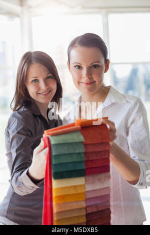 Ritratto di certi giovani imprenditrici scegliendo i campioni di tessuto in office Foto Stock