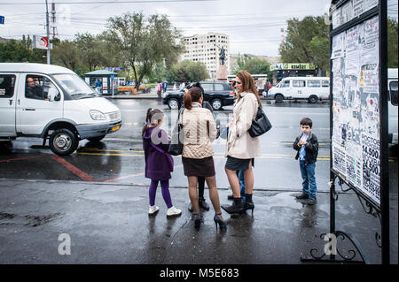 Piccola famiglia in attesa dopo de pioggia a Yerevan Vernissage open-air mercato delle pulci a Yerevan, Armenia. Foto Stock