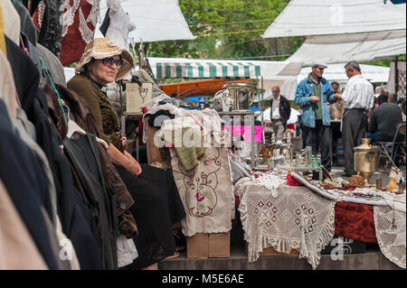 Vecchia Signora con cappello, in attesa di alcuni clienti al mercato delle pulci di Yerevan, Armenia. Foto Stock