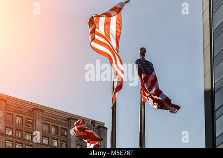 American bandiera nazionale contro il grattacielo alto, STATI UNITI D'AMERICA in una giornata di sole. Foto Stock