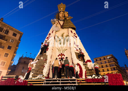 La gente mettendo tutte le offerte di fiori portato alla Vergine Maria durante la " Ofrena' processione come parte del Fallas feste a Valencia in Spagna. Foto Stock