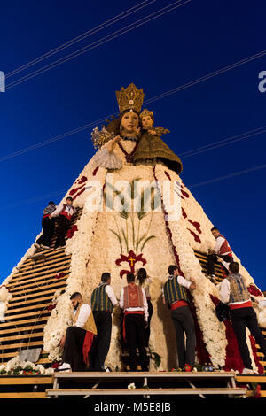 La gente mettendo tutte le offerte di fiori portato alla Vergine Maria durante la " Ofrena' processione come parte del Fallas feste a Valencia in Spagna. Foto Stock