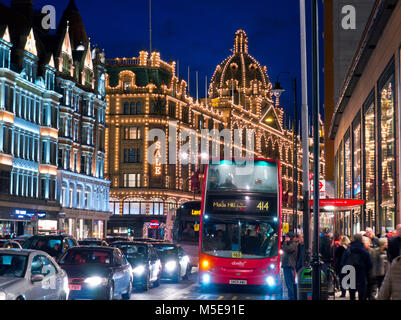 KNIGHTSBRIDGE VENDITA INVERNALE Harrods grande magazzino di notte illuminato 'Vendite' segno shoppers rosso autobus sfocato traffico Brompton Road Knightsbridge Londra SW1 Foto Stock