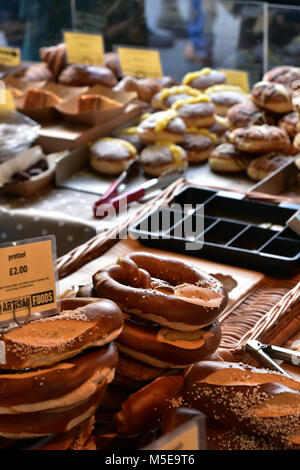 Zuccherino di tratta di torte e dolci in vendita su una bancarella al mercato di Borough di Londra. Il guadagno di peso mangiando ingrasso caricato zucchero dolci e torte al forno. Foto Stock