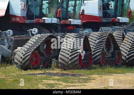 Cingolo in gomma le vie trebbiatrici mietitrebbia. Il parcheggio delle macchine agricole. Foto Stock