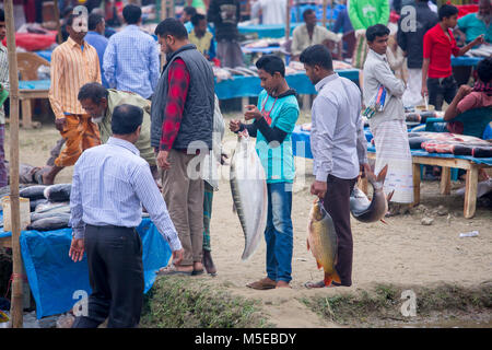 Una famiglia proprietaria è tornare a casa dopo aver acquistato un pesce dalla fiera (Poradah Mela) per la famiglia. Foto Stock