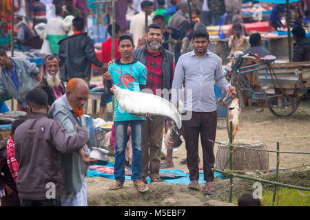 Una famiglia proprietaria è tornare a casa dopo aver acquistato un pesce dalla fiera (Poradah Mela) per la famiglia. Foto Stock