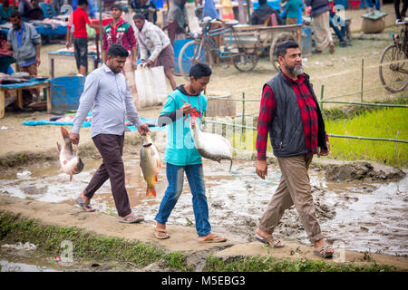 Una famiglia proprietaria è tornare a casa dopo aver acquistato un pesce dalla fiera (Poradah Mela) per la famiglia. Foto Stock
