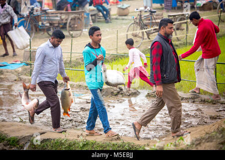 Una famiglia proprietaria è tornare a casa dopo aver acquistato un pesce dalla fiera (Poradah Mela) per la famiglia. Foto Stock