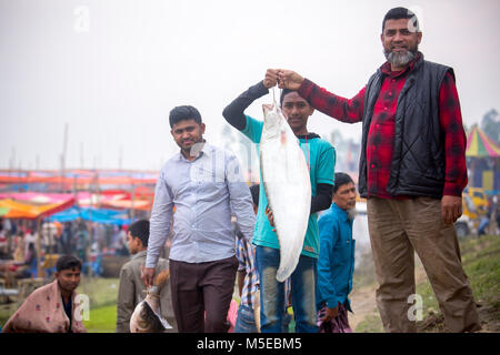 Una famiglia proprietaria è tornare a casa dopo aver acquistato un pesce dalla fiera (Poradah Mela) per la famiglia. Foto Stock