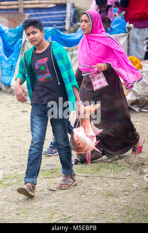 Un ragazzo giovane e sua madre è tornare a casa dopo aver acquistato un pesce dalla fiera (Poradah Mela) per la famiglia. Foto Stock