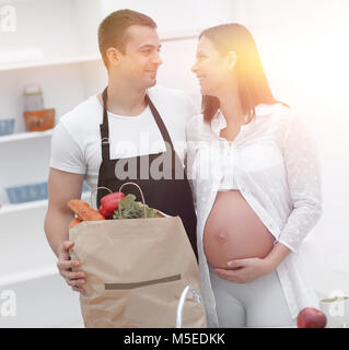 Il marito e la moglie incinta pettinatura sono attraverso il pack,supporto Foto Stock