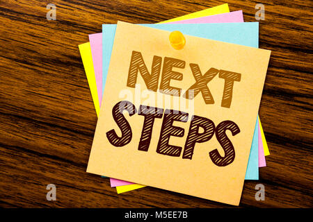 Mano concettuale di scrittura di testo Didascalia ispirazione che mostra le fasi successive. Il concetto di business per il futuro Golas e Bersaglio scritto su una nota adesiva carta su legno Foto Stock