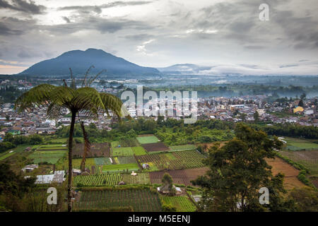 Maltempo circonda montagne di Berastagi rurale città di Sumatra. Elevato angolo di visione con contrastanti rurale ed urbano per la città con ampio angolo di paesaggio Foto Stock