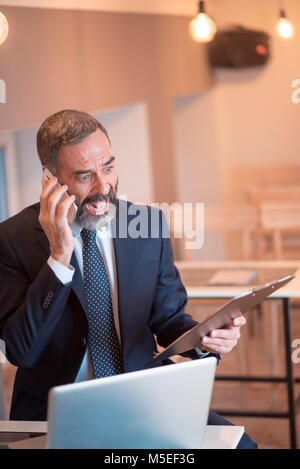 Angry business man a urlare contro il suo dipendente per un errore commesso su rapporti ufficiali Foto Stock