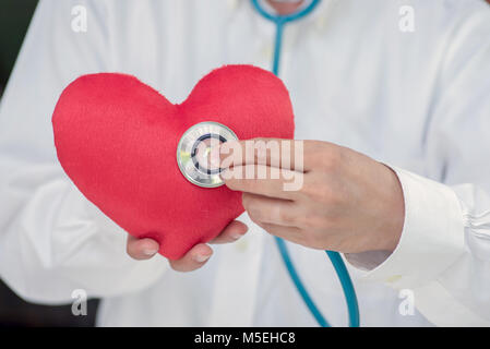 Verificare il tuo cuore con un medico presso la scrivania bianca. Foto Stock