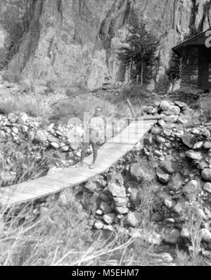 Grand Canyon storico - Bright Angel Creek Bridge Studente tedesco Ernst STOPLER, attraversando il ponte di sospensione a Bright Angel Creek. CIRCA 1929. , MCKEE. Foto Stock