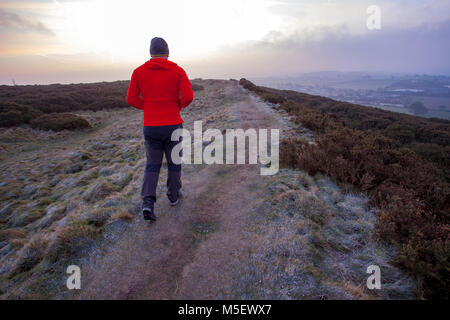 Flintshire, Wales, Regno Unito 23 febbraio 2018, UK meteo: Le temperature sono già cominciando a cadere come un artico massa aria si dirige verso il Regno Unito denominato bestia da est portando con sé molto freddo e neve nei prossimi giorni. Molti oggi si iniziano a sentire la come temperature è scesa ben al di sotto del congelamento di ieri sera come questo walker scoperto a piedi lungo un sentiero su un età di ferro hillfort vicino al villaggio di Halkyn, Flintshire © DGDImages/Alamy Live News Foto Stock