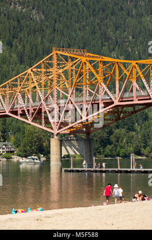 Nelson, British Columbia, Canada. Rotante parco sul lago spiaggia pubblica e l'autostrada 3A ponte al di sopra del braccio ovest del Lago Kootenay. Foto Stock