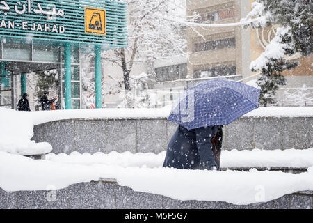 Dr Fatemi street Tehran, Iran - 28 gennaio 2018 donne esce dalla stazione metro con ombrello in giornata nevosa Foto Stock