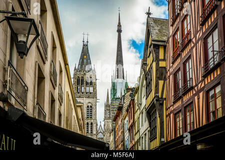 La strada principale di Rue du Gros Horloge con la cattedrale di Rouen tower e guglie in vista e per metà case con travi di legno lungo la strada Foto Stock