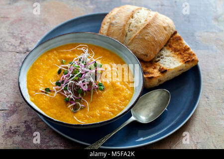 Zuppa di carote con il topping di germogli verdi Foto Stock