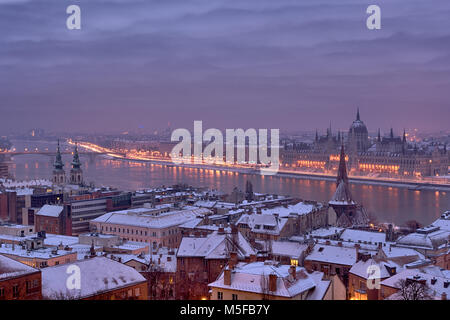 Vista notturna di Budapest city, tetti coperti di neve, fiume, il Parlamento Foto Stock