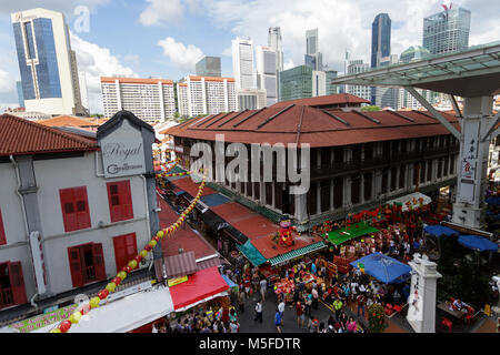 Scena dalla strada dello shopping di Chinatown in Singapore presso il capodanno cinese con lo skyline di Singapore in background Foto Stock