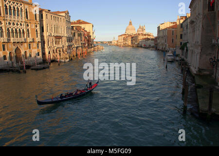 Una gondola sul Canal Grande Venezia vista dal ponte dell Accademia (Ponte dell'Accademia) con la Chiesa di Santa Maria della Salute, in background. Foto Stock