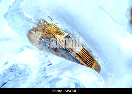 Congelati New British una sterlina moneta fino vicino all'interno della macro di cubetti di ghiaccio. Foto Stock