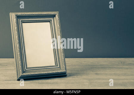 Vintage photo frame su un tavolo di legno su sfondo grunge, ancora lo stile di vita Foto Stock