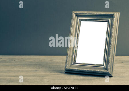 Blank vintage photo frame su un tavolo di legno su sfondo grunge, salva percorso di clipping. Foto Stock