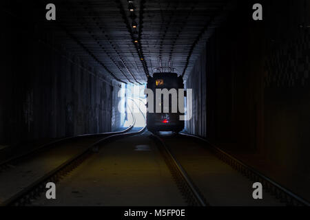 Il tram silhouette contro la luce alla fine del tunnel Foto Stock