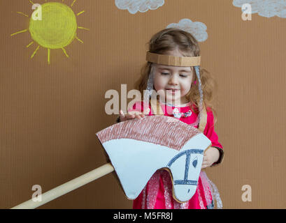 Ritratto di un bambino giocoso con una tuta di cartone su stick cavallo. in stile vintage. Foto Stock