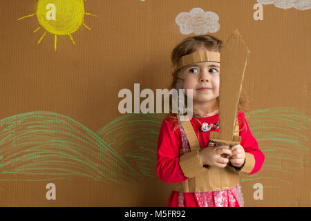 Ritratto di un bambino giocoso con una spada di cartone e un abito stile vintage Foto Stock